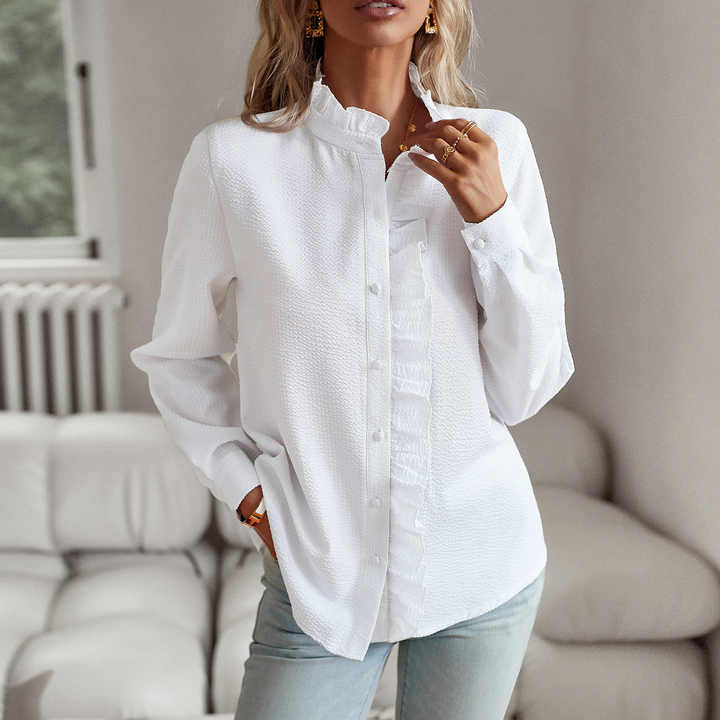 White long sleeve ruffled blouse worn with jeans, three quarter front view