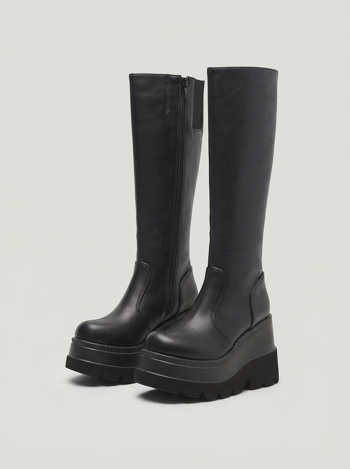 Black knee high wedge boots with a deep lug sole, the pair seen from the front