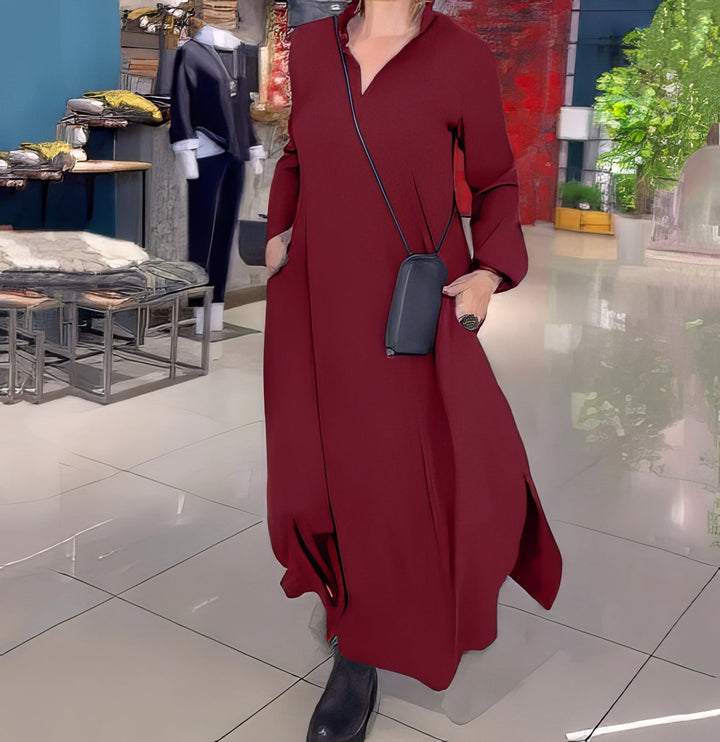Front view, model in a red stretch maxi dress with side slits and a small black shoulder bag