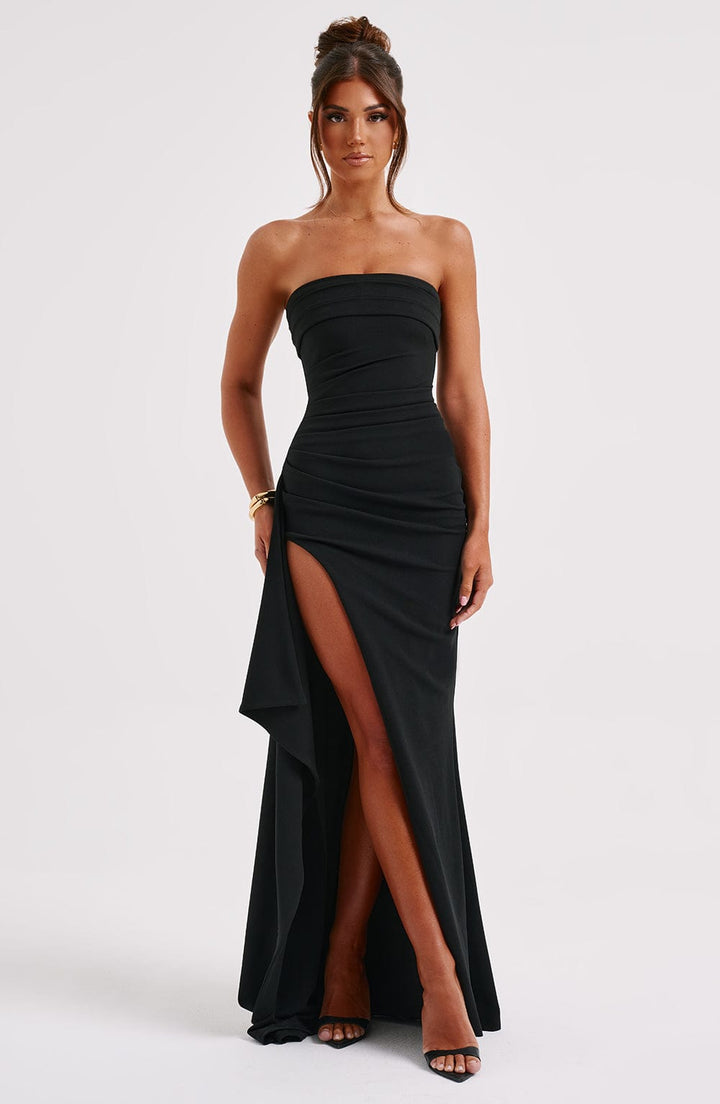Front view of a model wearing a black strapless elegant high split maxi dress with ruched detailing