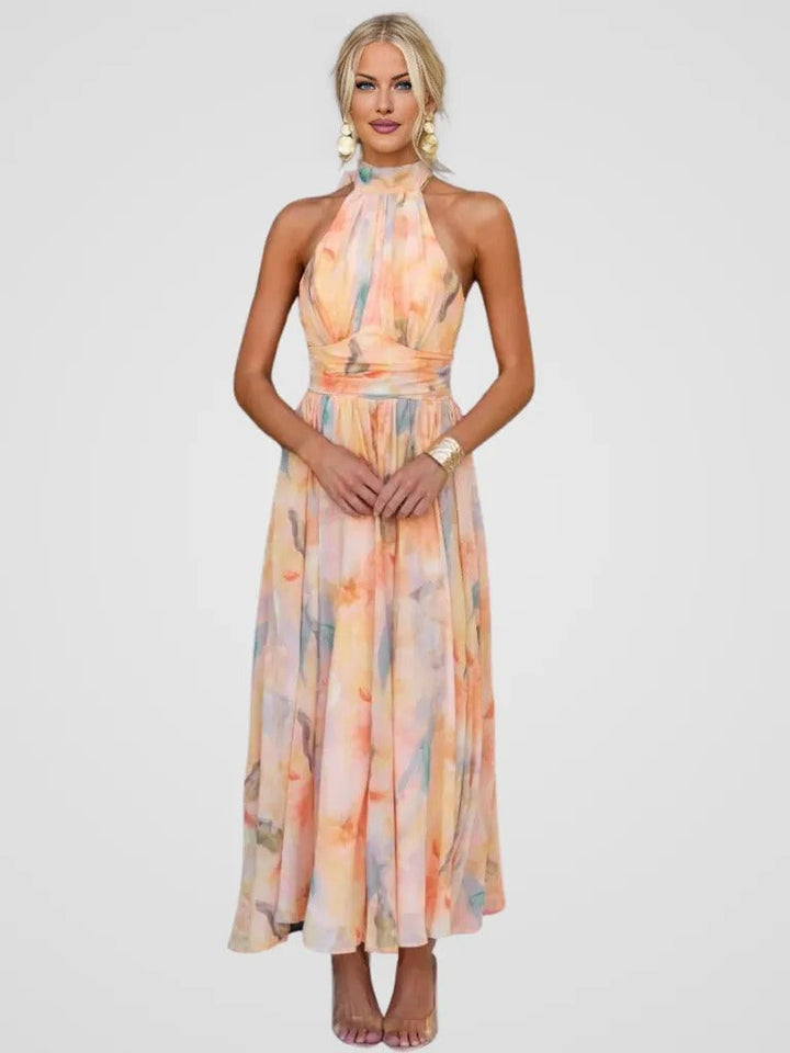Front view of a model wearing the elegant blossom halter long dress with a colourful pastel print