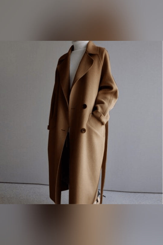 Front view of a camel Florence premium blend wool coat over a white turtleneck, with hands in pockets
