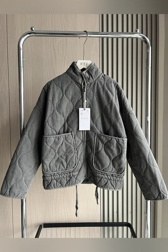 Front view of a grey women's vintage quilted cotton jacket with a high collar and two large front pockets