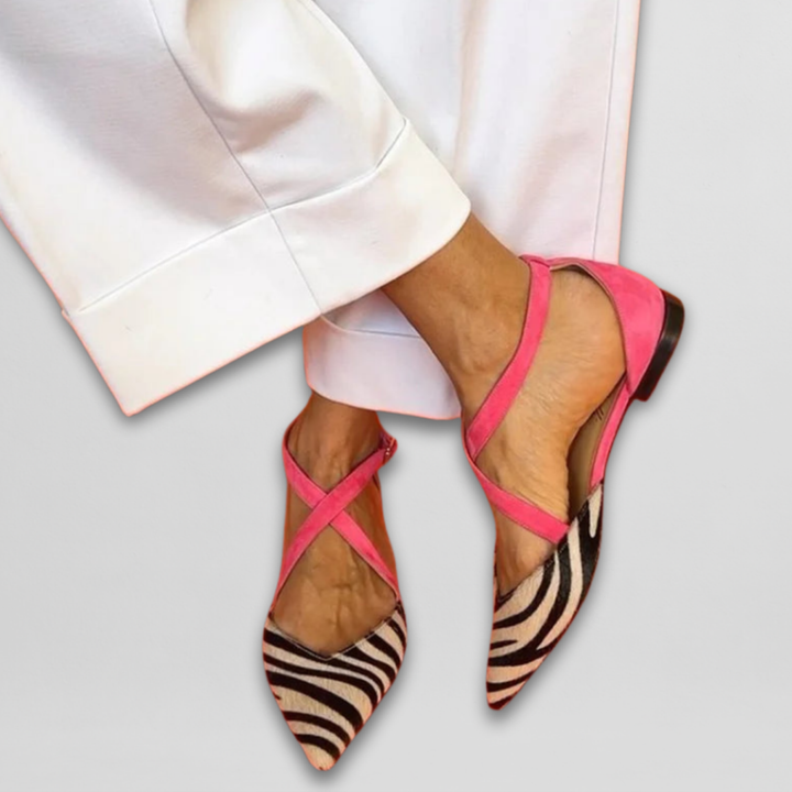 Pink zebra print pointed toe flats worn with white wide leg trousers