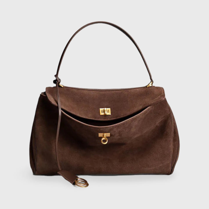 Front view of a brown suede shoulder bag with gold hardware and a long strap with gold rings