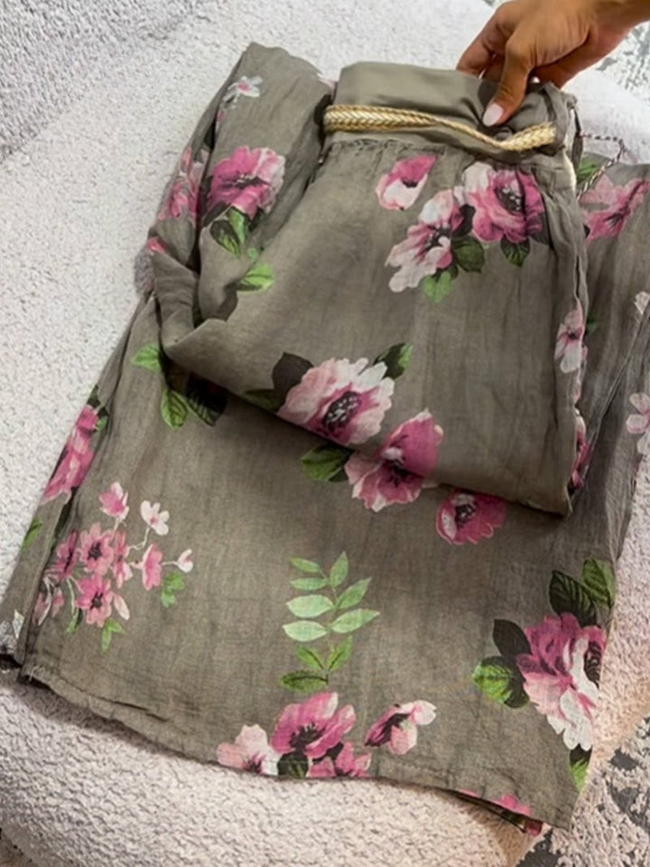 Detail view of folded floral print cotton linen pants with a braided drawstring waist