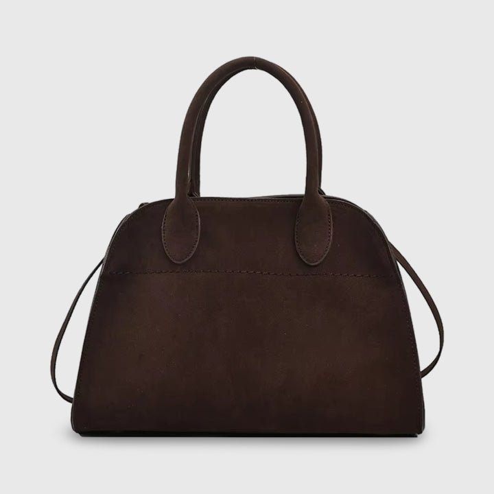 Front view of a dark brown suede mini bag with top handles and a thin shoulder strap