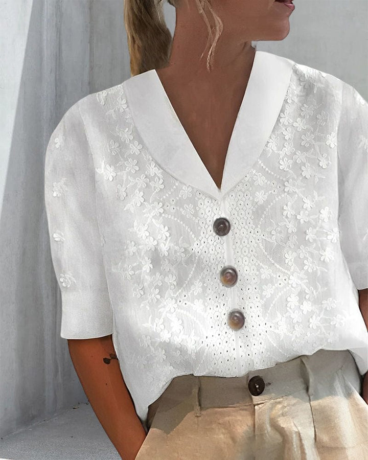 Front view worn by model, white floral cotton linen blouse with puff sleeves and brown buttons