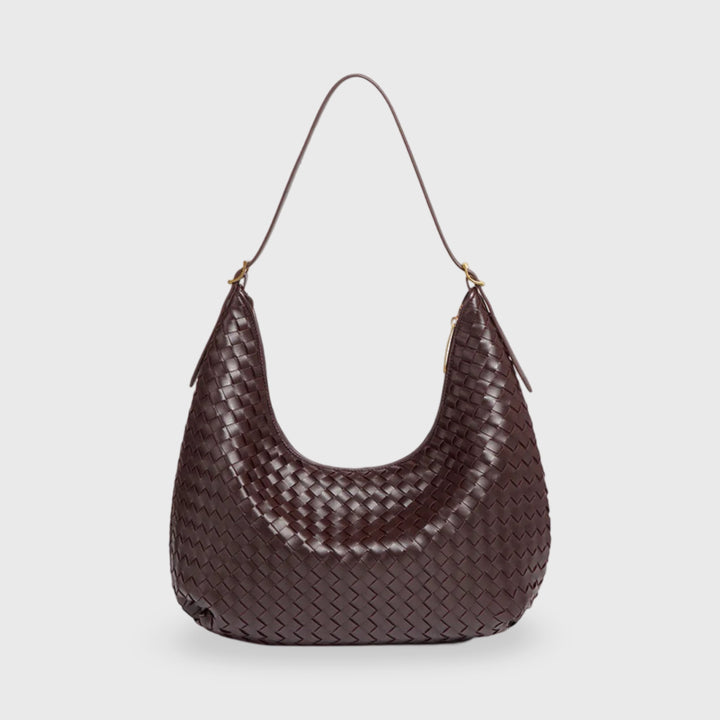 Front view of a dark brown woven mini handbag with a curved shape and a thin shoulder strap