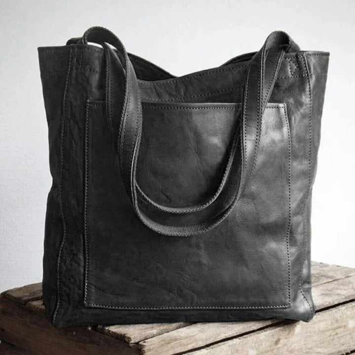 Back view of the Josie leather handbag in black with an external pocket and twin shoulder straps