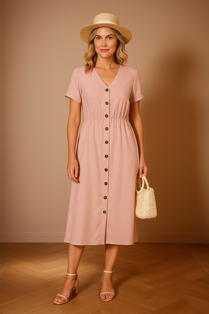 Front view, model wearing a Quinn Button-Up Dress in pink with a straw hat and bag