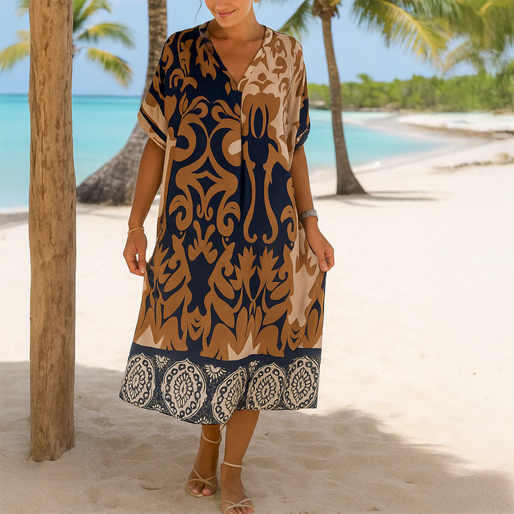 Front view of a model wearing the Breezy Printed V-Neck Midi Dress on a sandy beach