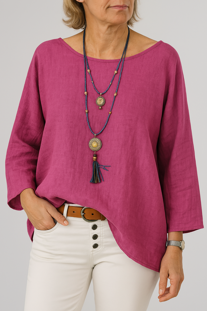 Front view, model wearing a pink oversized cotton-linen tunic with a boat neck and three quarter sleeves