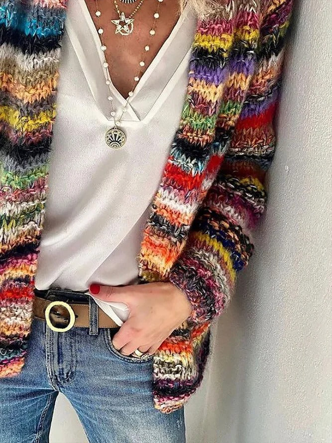 Front view, worn by model, showing the vibrant Icelandic pattern sweater over a white top and jeans