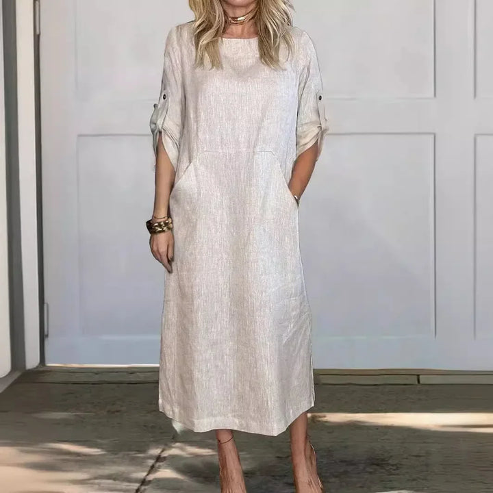 Front view of the Emma Linen Midi Dress on a model, showcasing the rolled short sleeves and side pockets