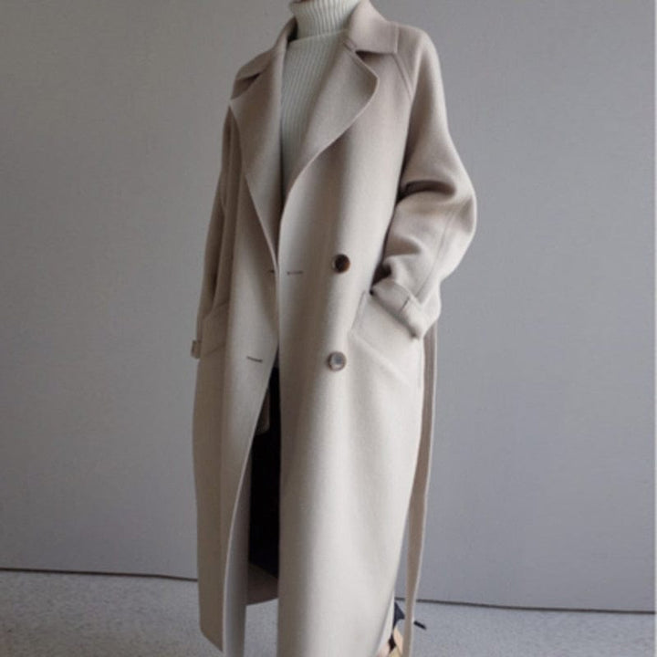Front view of a camel Florence premium blend wool coat, worn open over a white turtleneck, hands in pockets