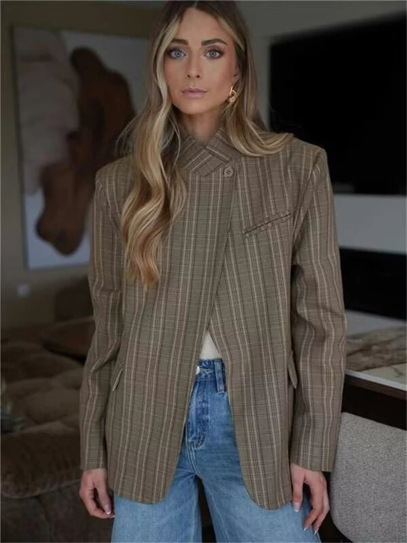 Worn by model, a brown plaid blazer with an asymmetric closure and buttoned collar