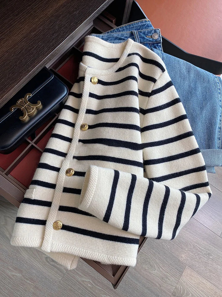 Front view of a cream striped knit crop cardigan with navy stripes and gold buttons, styled with jeans