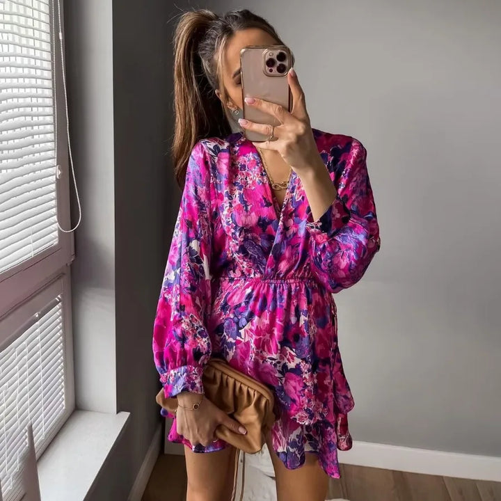 Elegant long-sleeve evening dress worn by model, front view, with a vibrant pink and purple floral print