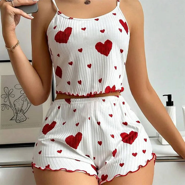 Front view of a model wearing a white pyjama set with red hearts, a cropped cami and matching shorts