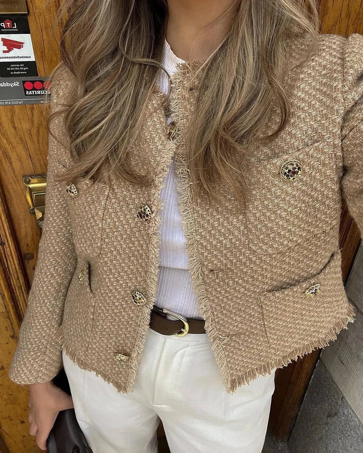 Front view worn by model of a chic tweed buttoned jacket with fringe trim and decorative buttons