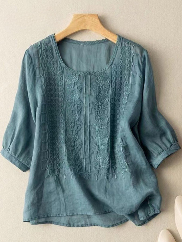 Front view of a teal mid sleeve cotton linen embroidery blouse on a hanger