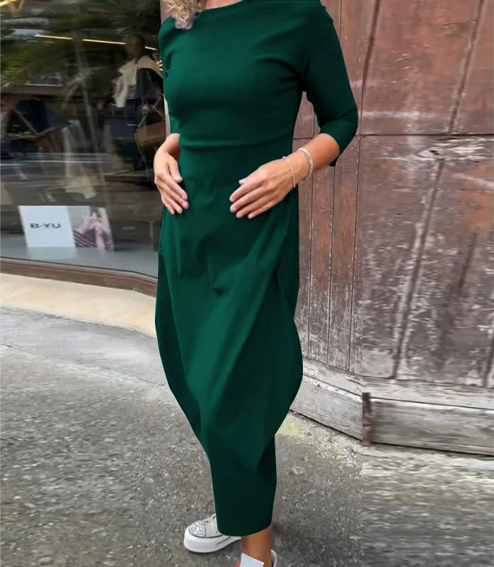 Front view of a model wearing the Lana A-Line Dress in dark green with hands in pockets