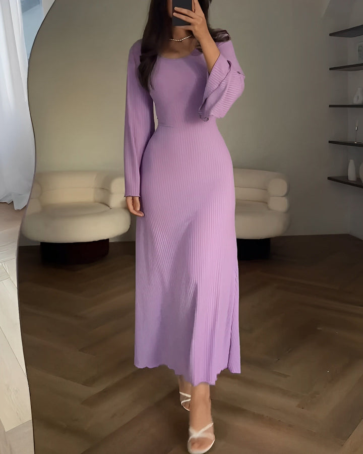 Side view of a model wearing a lilac elegant knit maxi dress, showing flared sleeves and ribbed texture