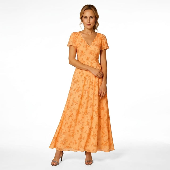 Front view, model wearing a colourful maxi summer dress with a V-neck and short flutter sleeves, hands at sides