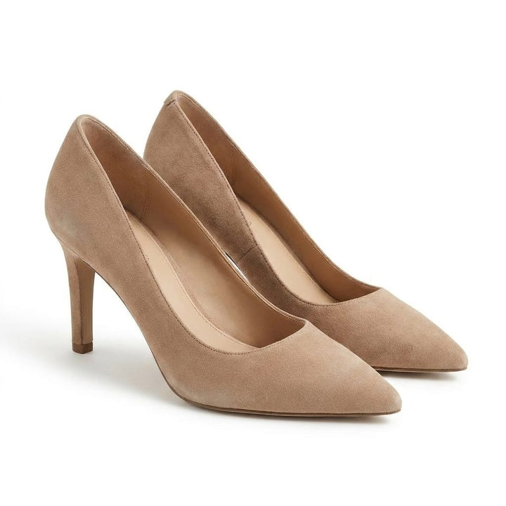 Three quarter view of two beige suede high heel boots with pointed toes and thin heels