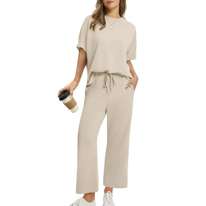 Front view, model wearing a comfortable two-piece casual top and pants set in beige with a coffee cup