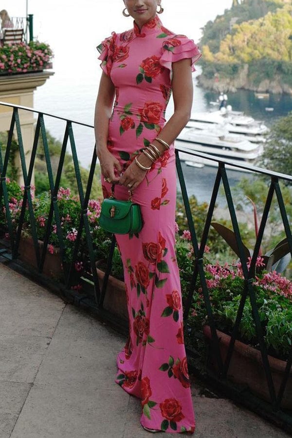 Front view, elegant rose floral print long dress with ruffled sleeves worn by model on a balcony