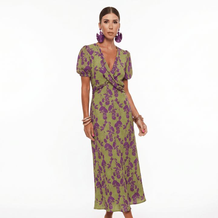 Front view, model wearing a sophisticated summer dress in green with a purple floral print and puff sleeves