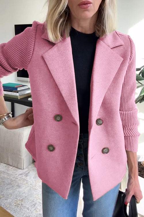 Front view of a model wearing the pink button patchwork sleeve casual coat over a black top and blue jeans