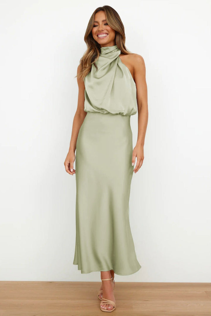 Front view of a model wearing a light green satin halter neck maxi dress with a relaxed bodice and fitted skirt