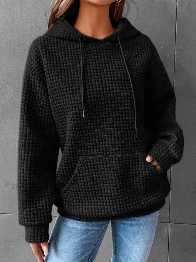 Front view of a model wearing the black oversized cotton hoodie with drawstring and front pocket