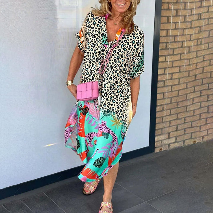 Front view of a model wearing a casual leopard print dress with a colourful animal print skirt and pink bag
