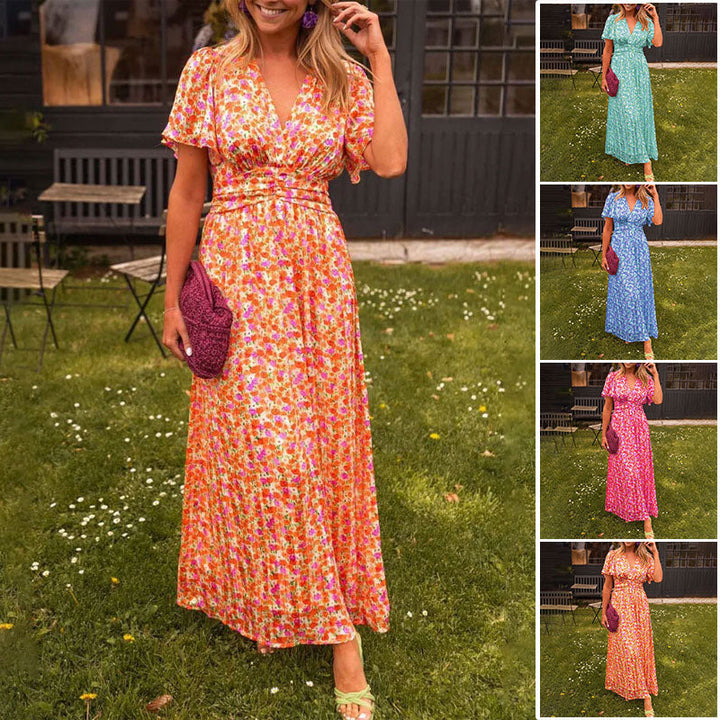 Front view, model wearing a floral print breezy summer dress in orange with a V-neck and short sleeves