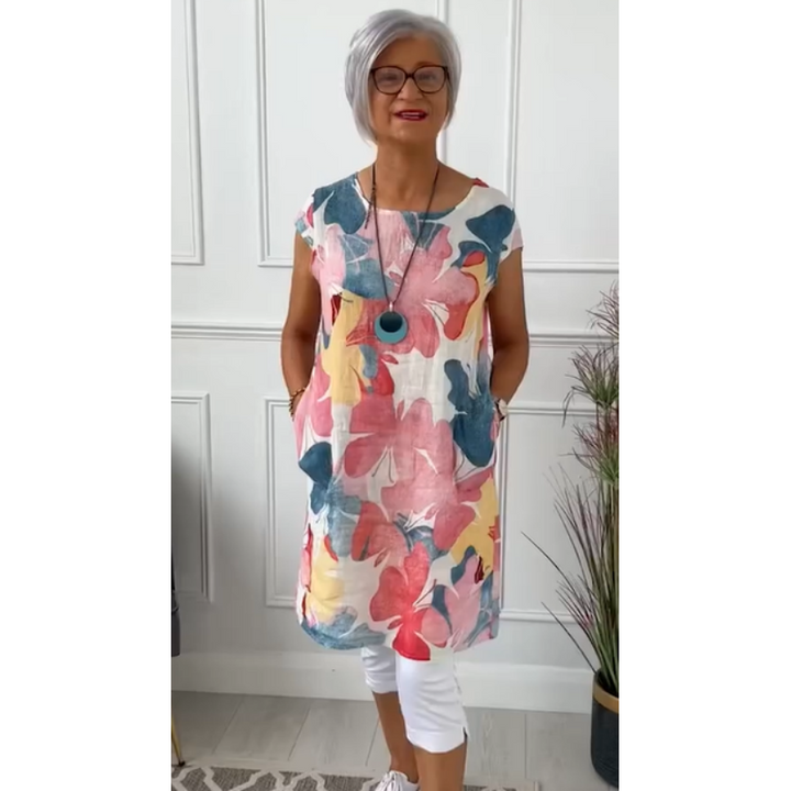 Front view of an elegant shirt dress worn by a model, featuring a colourful floral print and a round neckline