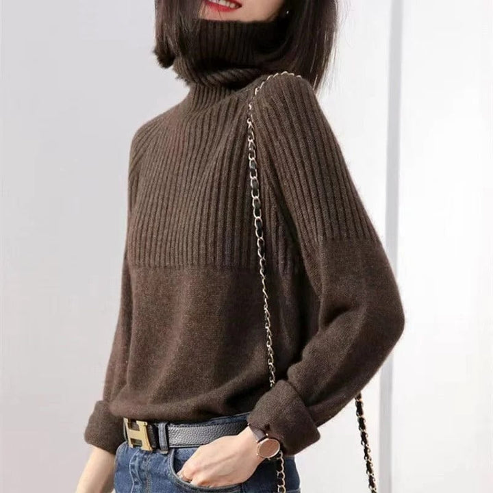 Front three quarter view of a model wearing a brown ribbed turtleneck jumper with a black belt and jeans